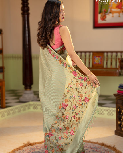 Tissue saree pastel green with allover zari stripe pattern and embroidery border