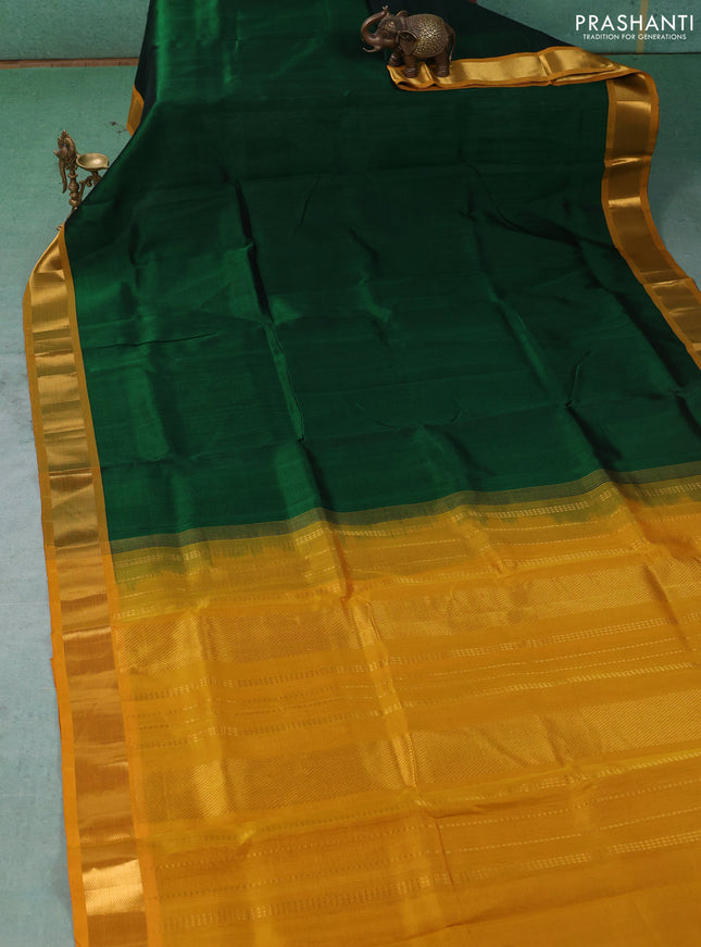 Silk cotton saree bottle green and mustard yellow with plain body and zari woven border