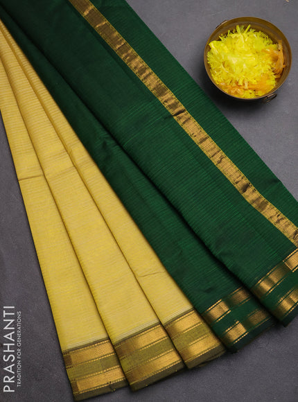 Silk cotton saree pale yellow and bottle green with plain body and zari woven border