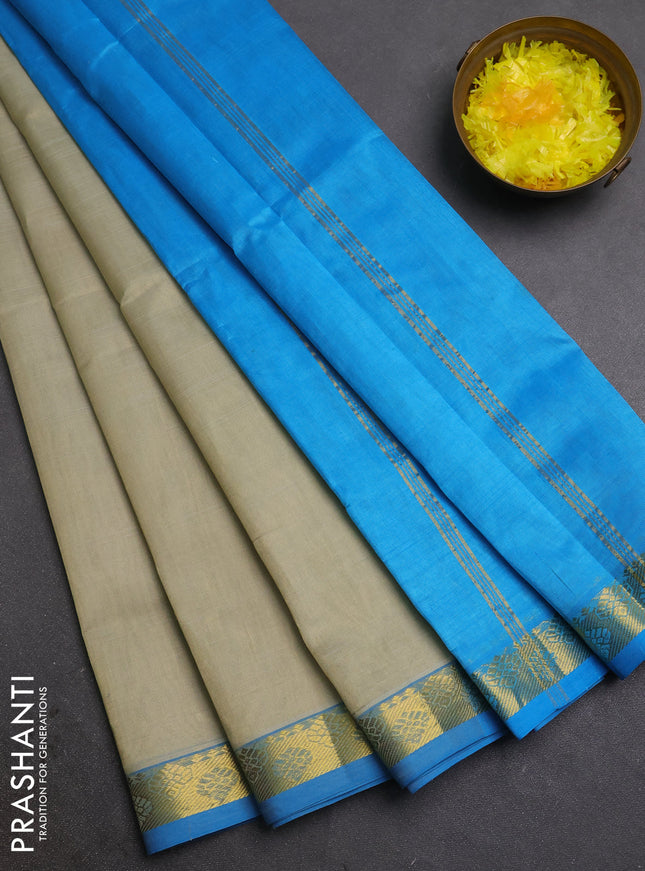 Silk cotton saree beige and cs blue with plain body and zari woven border
