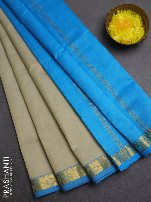 Silk cotton saree beige and cs blue with plain body and zari woven border