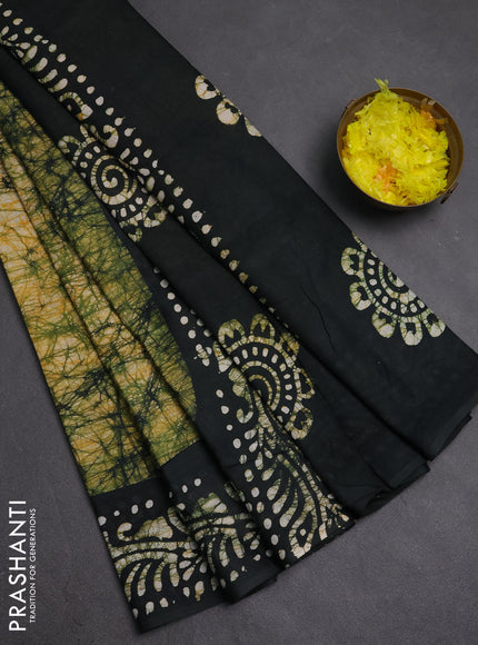 Batik cotton saree bottle green with allover prints and batik printed border