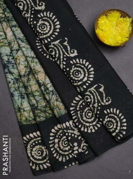 Batik cotton saree bottle green with allover prints and batik printed border