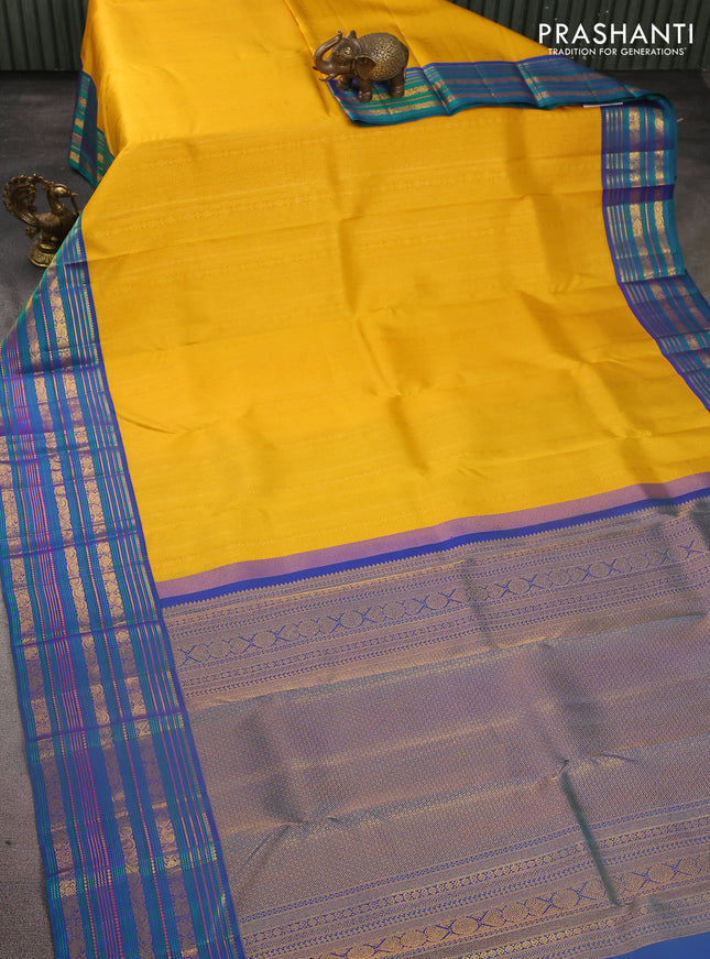 Pure kanchipuram silk saree yellow and peacock blue with allover zari woven brocade weaves and zari woven korvai border