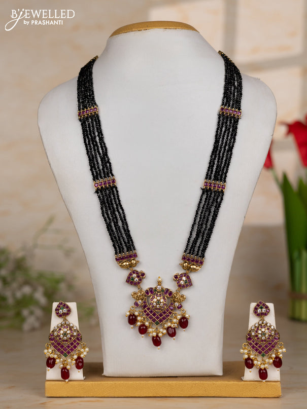 Beaded black necklace with floral pendant in kemp and maroon beads hanging