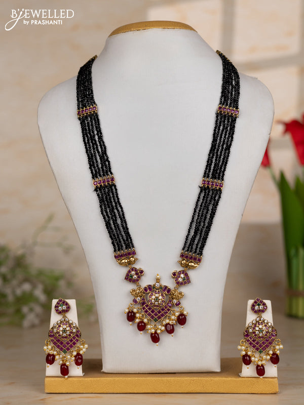 Beaded black necklace with floral pendant in kemp and maroon beads hanging
