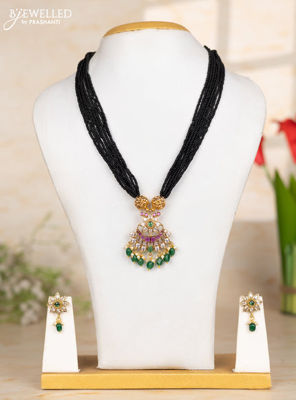 Beaded black necklace with floral pendant in kemp and green beads hanging
