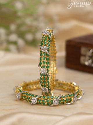 Zircon bangles with emerald stones in gold finish