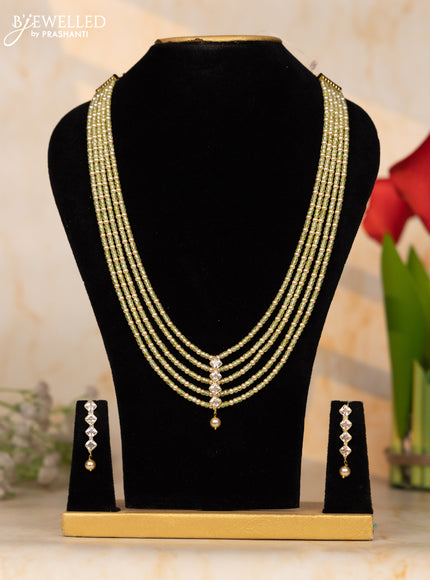 Beaded light green necklace with white stone pendant at the center
