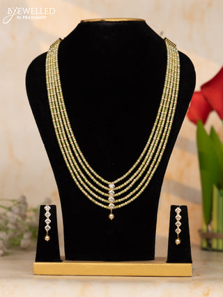 Beaded light green necklace with white stone pendant at the center