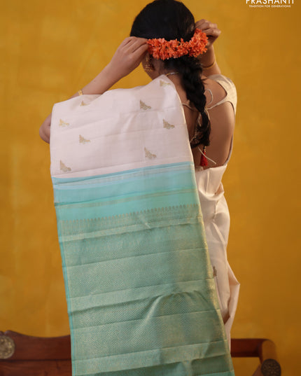 Off white-Teal blue Pure Kanchipuram silk saree With Zari woven peacock buttas