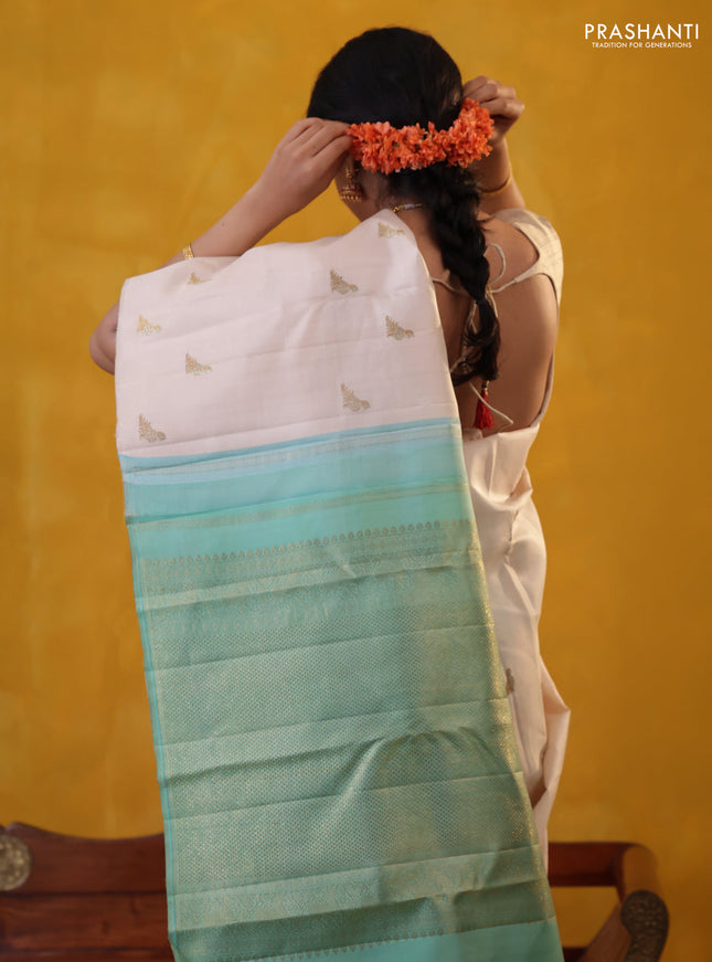Off white-Teal blue Pure Kanchipuram silk saree With Zari woven peacock buttas