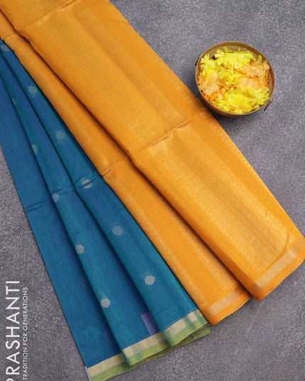 Kora silk cotton saree dual shade of bluish green and mustard yellow with zari woven floral buttas and zari woven border
