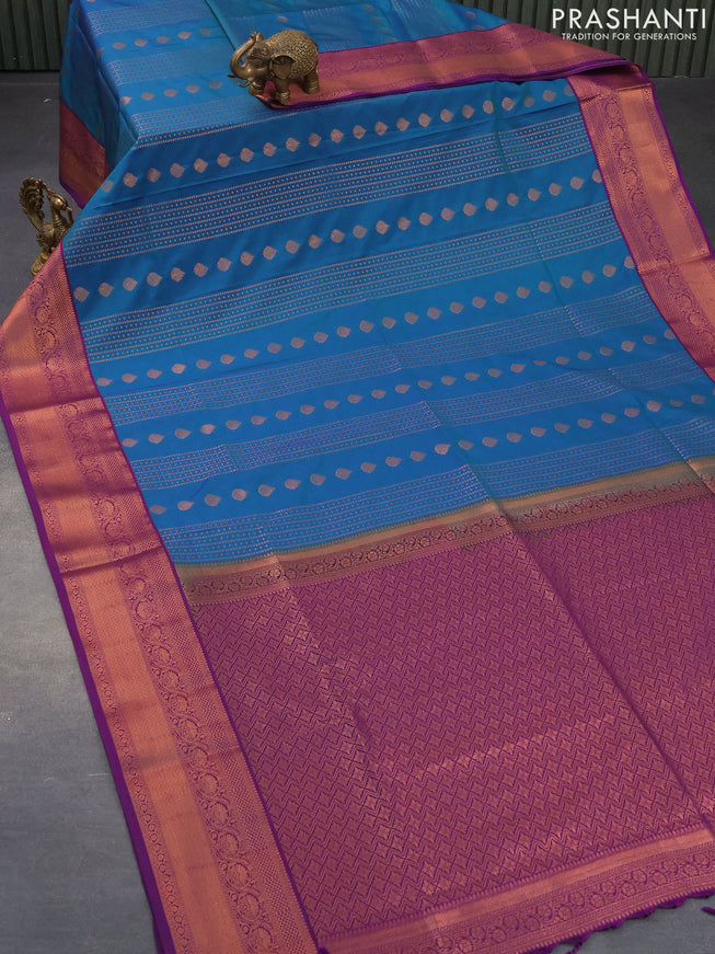 Semi soft silk saree dual shade of bluish green and purple with allover copper zari weaves and copper zari woven border