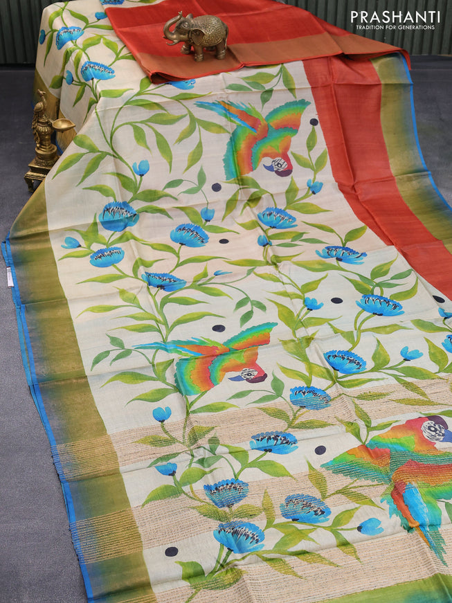Pure tussar silk saree beige rustic orange and cs blue with allover floral hand painted prints and zari woven border