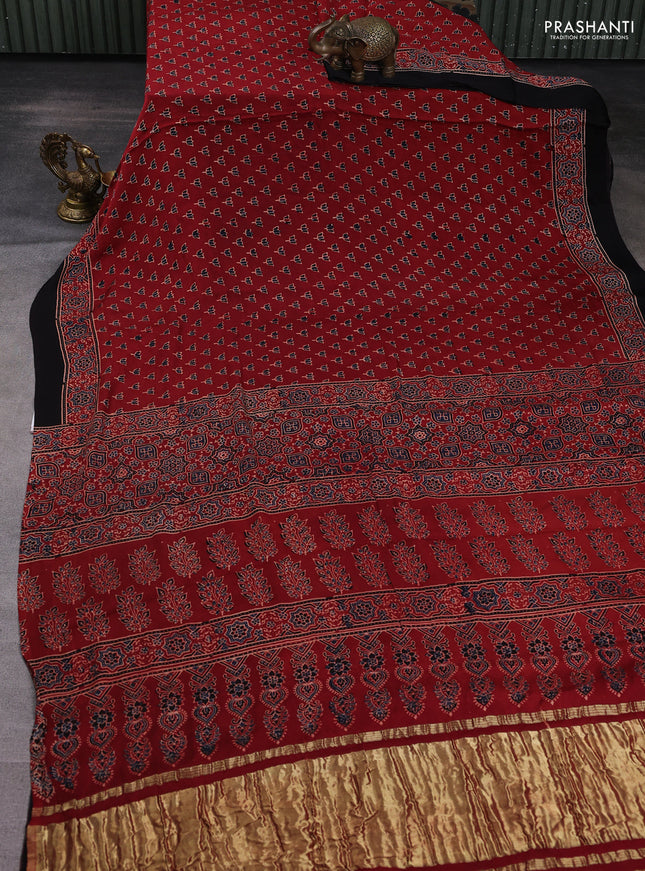 Modal silk saree rust shade and black with allover ajrak butta prints and zari woven pallu