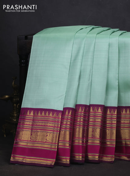 Pure kanchipuram silk saree teal shade and purple with plain body and long zari woven korvai border