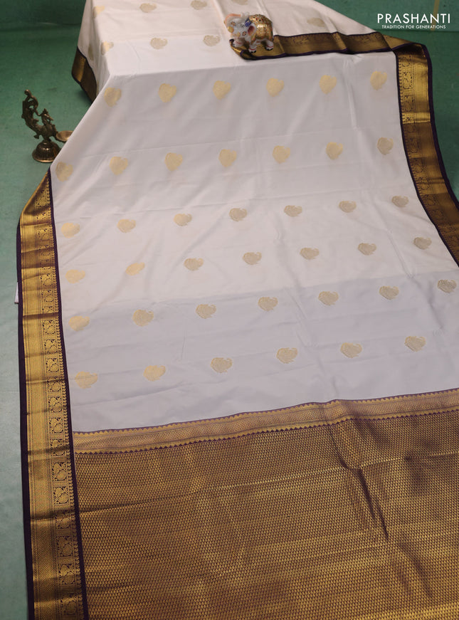 Semi kanchipuram silk saree cream and deep purple with zari woven paisley buttas and zari woven korvai border