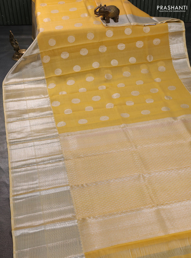 Kora kanchipuram silk saree yellow and pale yellow with silver zari woven buttas and long silver zari woven border