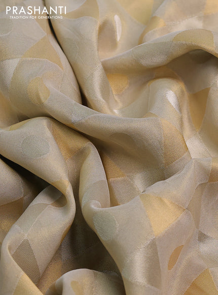 Banarasi tissue saree beige and dark green with allover zari woven geometric wevaes and lace work border