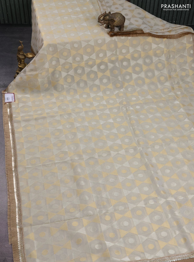 Banarasi tissue saree beige and pink with allover zari woven geometric wevaes and lace work border