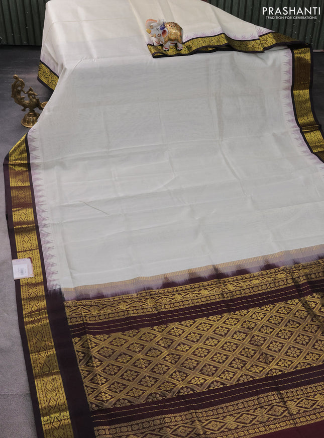 Silk cotton saree off white and coffee brown with plain body and temple design zari woven korvai border