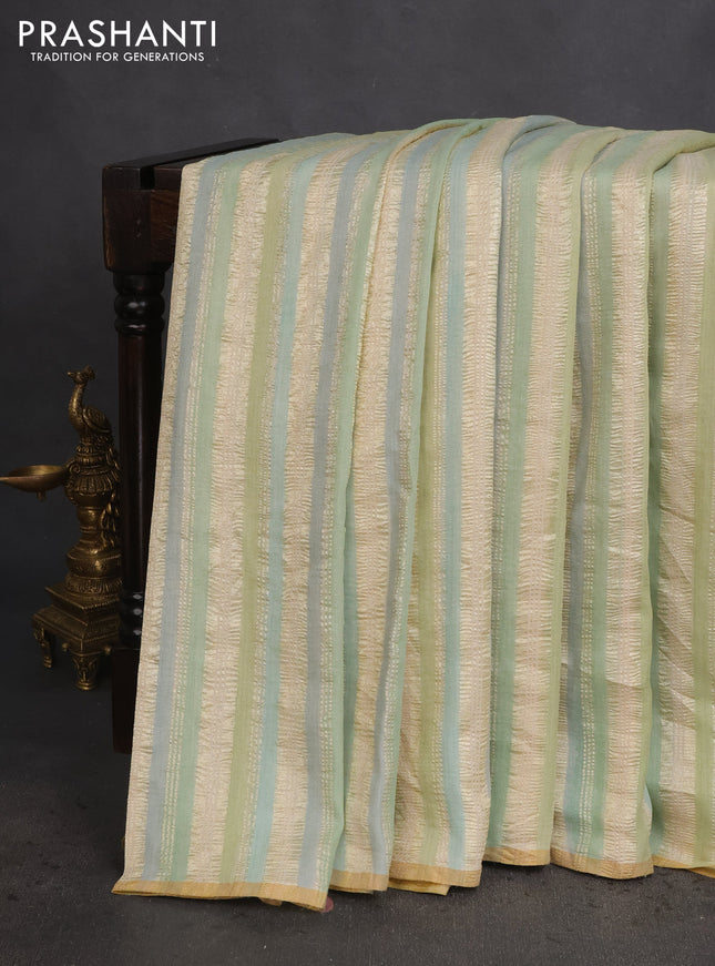 Munga silk saree pastel green and pastel blue with allover zari woven stripes pattern in borderless style