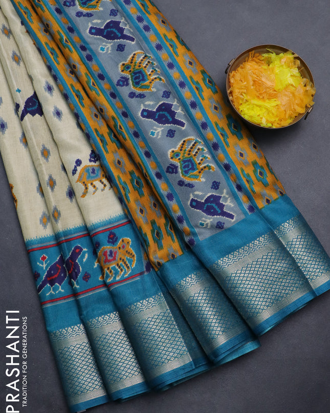 Semi dola saree cream and teal blue with allover patola prints and zari woven border