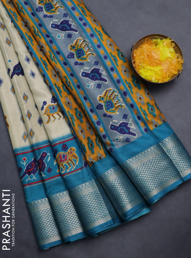 Semi dola saree cream and teal blue with allover patola prints and zari woven border
