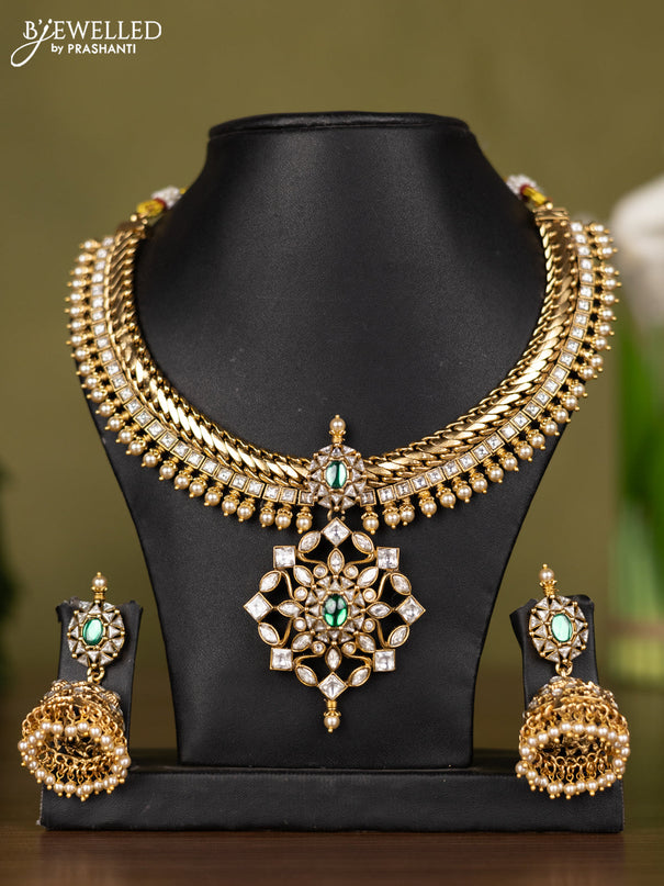 Antique necklace with floral design in kundan stones and pearl throughout the neckline