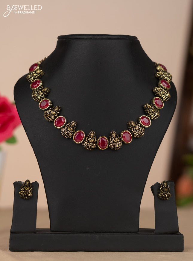Oxidised necklace with lakshmi design and red stone in gold finish