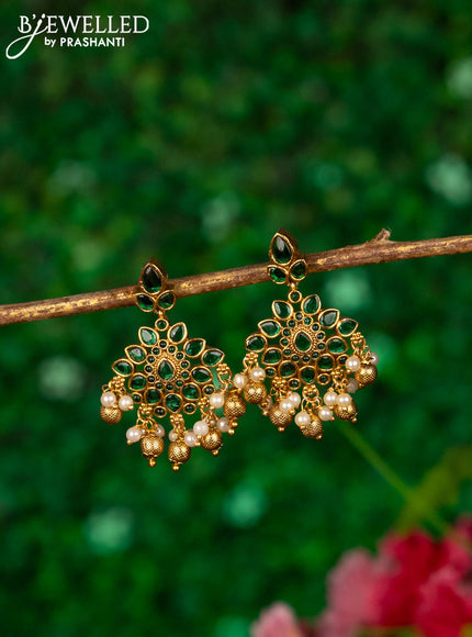 Antique earrings with emerald stones and golden beads hanging