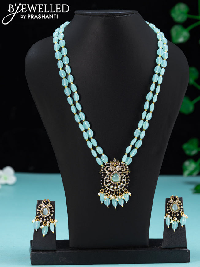 Beaded double layer ice blue necklace with peacock design cz stones and beades hanging in victorian finish