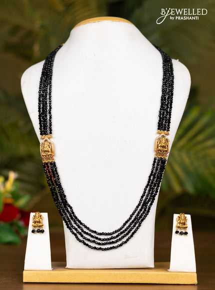 Beaded black necklace with antique lakshmi pendant in white stones