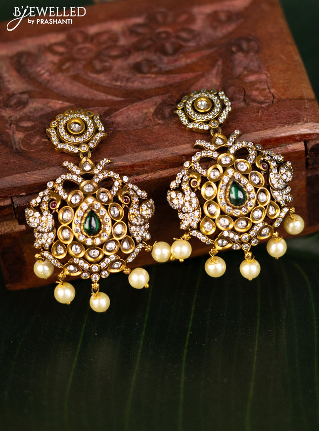 Earrings with emerald & cz stones and pearl hangings in victorian finish