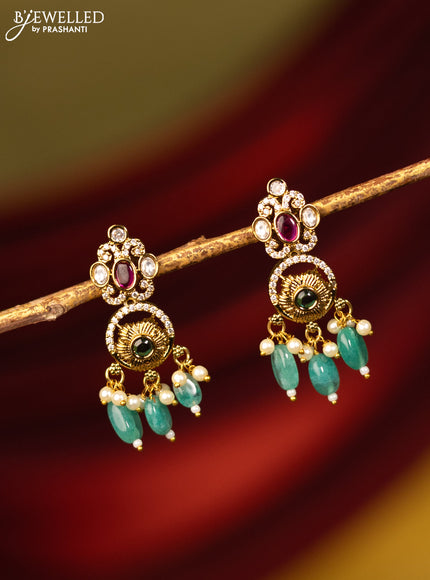 Earrings with kemp & cz stones and green beads hanging in victorian finish