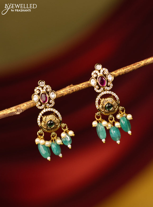 Earrings with kemp & cz stones and green beads hanging in victorian finish