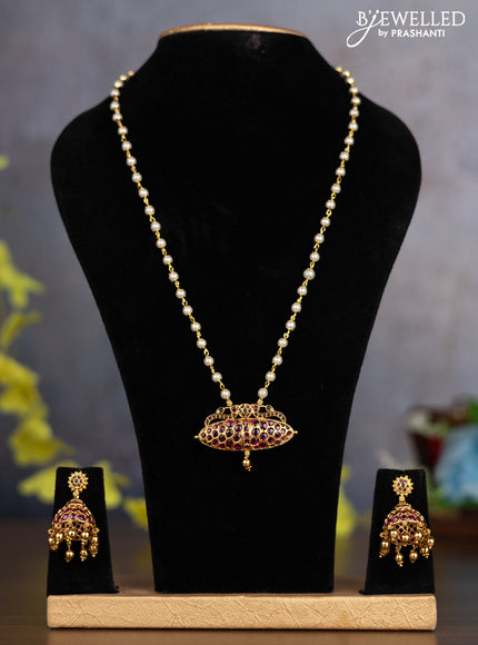 Pearl necklace with kemp stones and golden beads hanging