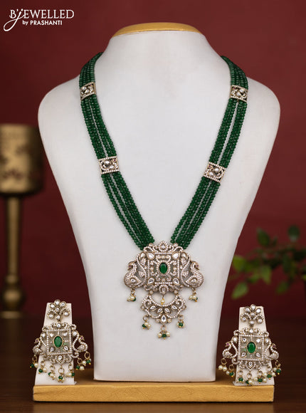Beaded multilayer green necklace with emerald kundan & cz stones and pearl & beads hanging in victorian finish