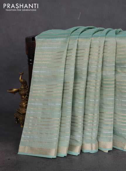 Tissue silk saree pastel green shade with allover silver & gold zari weaves and zari woven border