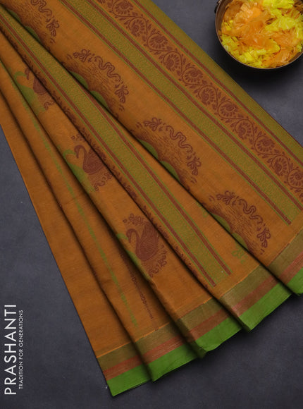 Nithyam cotton saree dark mustard and green with allover self emboss & thread woven buttas and simple border