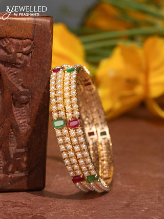 Pearl bangles with kemp stones and pearls in gold finish