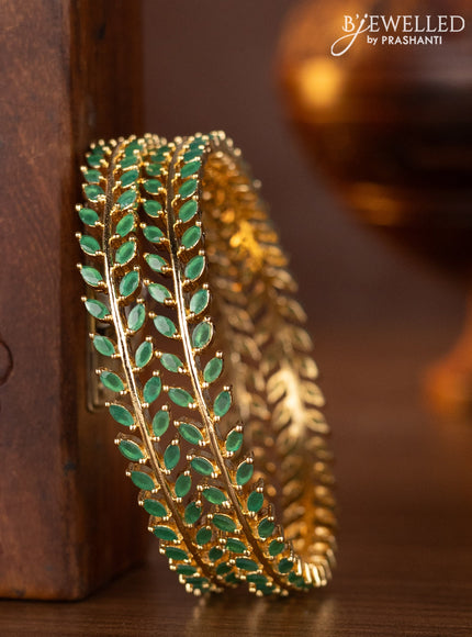 Zircon bangles with emerald stones in gold finish