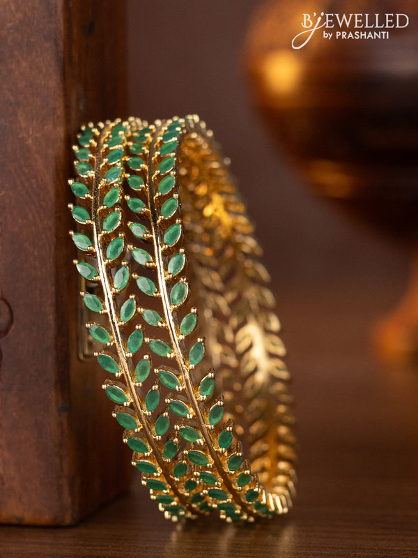 Zircon bangles with emerald stones in gold finish