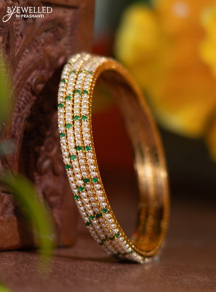 Pearl rajawadi bangle with emerald stones and pearls in gold finish