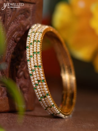 Pearl bangle with emerald stones and pearls in gold finish