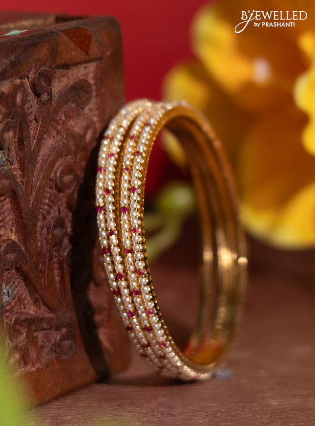 Pearl rajawadi bangles with ruby stones and pearls in gold finish
