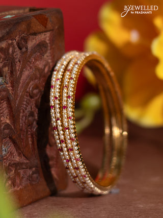 Pearl bangles with ruby stones and pearls in gold finish