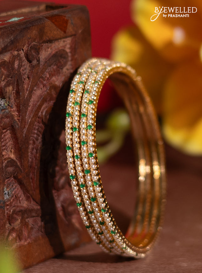 Pearl rajawadi bangles with emerald stones and pearls in gold finish