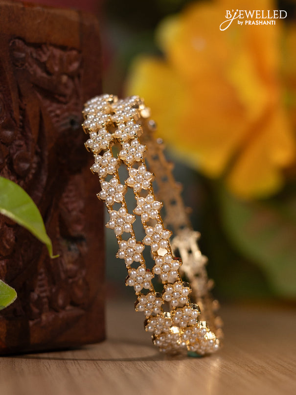 Pearl bangles with floral design and pearls in gold finish
